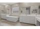 Bright bathroom showcasing a soaking tub, double vanity with mirrors, and wood-style tile at 8 Reflection Cove Dr, Henderson, NV 89011