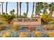 A community sign featuring the name 'The Outlook' is surrounded by cacti and palm trees at 8 Reflection Cove Dr, Henderson, NV 89011