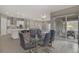Bright open dining area features modern lighting, table with seating for six, and sliding glass doors to the outdoor living space at 8 Reflection Cove Dr, Henderson, NV 89011