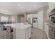 Bright, open kitchen featuring a large island with seating, stainless steel appliances, and modern white cabinetry at 8 Reflection Cove Dr, Henderson, NV 89011