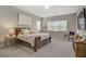 Well-lit main bedroom features a large bed, neutral decor, and a mounted television at 8 Reflection Cove Dr, Henderson, NV 89011