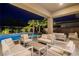 Relaxing outdoor patio with comfortable seating overlooking the pool and palm trees at 8 Reflection Cove Dr, Henderson, NV 89011