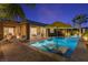 Beautiful outdoor pool area with a sunshade, in-pool chairs, and a patio with a fire pit at 8 Reflection Cove Dr, Henderson, NV 89011