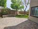 Relaxing backyard featuring a paved patio, artificial grass, and well-maintained landscaping at 8088 Smoking Jacket Pl, Las Vegas, NV 89166
