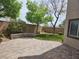 A paved patio with well-maintained lawn, trees, and privacy wall offers a relaxing outdoor space at 8088 Smoking Jacket Pl, Las Vegas, NV 89166