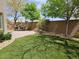Lush backyard offering a patio with outdoor seating, artificial turf, and mature trees at 8088 Smoking Jacket Pl, Las Vegas, NV 89166