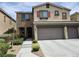 Two-story home featuring a stone facade, a two-car garage, and well-manicured landscaping at 8088 Smoking Jacket Pl, Las Vegas, NV 89166