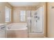 Bright bathroom featuring a soaking tub next to a glass-enclosed shower with tiled walls at 8112 Sapphire Sea St, North Las Vegas, NV 89085