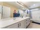 Well-lit bathroom with double sinks, white cabinetry, and a bathtub-shower combo at 8112 Sapphire Sea St, North Las Vegas, NV 89085