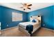 Cozy bedroom with blue walls, a ceiling fan, a queen bed, and a bright window at 8112 Sapphire Sea St, North Las Vegas, NV 89085