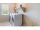 Bright laundry room features tile floors, a shelf, and updated, front-loading washer and dryer at 8112 Sapphire Sea St, North Las Vegas, NV 89085