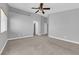 This carpeted bedroom offers neutral walls, a ceiling fan and an open doorway at 8658 Tom Noon Ave # 103, Las Vegas, NV 89178