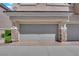 Garage featuring an automatic door, stone pillars, and a brick driveway at 8658 Tom Noon Ave # 103, Las Vegas, NV 89178