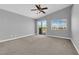 Main bedroom featuring a ceiling fan, carpet, and balcony access with views at 8658 Tom Noon Ave # 103, Las Vegas, NV 89178