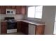 Kitchen featuring wood cabinets, an oven, dishwasher, and a window that provides natural light at 8970 Flying Frog Ave, Las Vegas, NV 89148