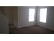 Well-lit living room with neutral walls, two windows, and stairs with carpet leading to the second floor at 8970 Flying Frog Ave, Las Vegas, NV 89148