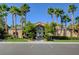 Community clubhouse with decorative glass entrance, palms, and ample parking at 8985 S Durango Dr # 2014, Las Vegas, NV 89113