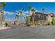 Community entrance with palm trees, gate, and manicured landscaping at 8985 S Durango Dr # 2014, Las Vegas, NV 89113