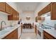 Galley kitchen featuring white appliances and oak cabinets that opens to the dining area at 8985 S Durango Dr # 2014, Las Vegas, NV 89113