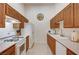 Galley kitchen with white appliances, oak cabinets, and bright countertops at 8985 S Durango Dr # 2014, Las Vegas, NV 89113