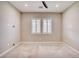 Neutral bedroom with carpet, ceiling fan, two windows and white window shutters at 9057 N Skye Treeline St, Las Vegas, NV 89166