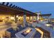 Cozy outdoor patio featuring a stone fire pit, comfortable seating, and a pergola with lovely landscape views at 9057 N Skye Treeline St, Las Vegas, NV 89166