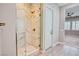 Luxurious glass shower with white marble-style tiling, gold fixtures, and pebble floor at 9057 N Skye Treeline St, Las Vegas, NV 89166