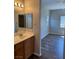 Bathroom with natural wood vanity, vanity mirror, and view into a bedroom at 9303 Gilcrease Ave # 1097, Las Vegas, NV 89149