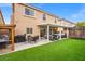 Lush backyard featuring a covered patio, built-in grill, and well-maintained turf at 9768 Fox Estate St, Las Vegas, NV 89141