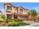 Charming two-story home with a well-manicured lawn, desert landscaping, and a brick driveway and garage at 9768 Fox Estate St, Las Vegas, NV 89141