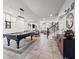 Spacious game room with a pool table, stylish decor, and open access to the living area and staircase at 9768 Fox Estate St, Las Vegas, NV 89141
