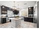 Modern kitchen featuring dark cabinets, stainless steel appliances, and granite countertops at 9768 Fox Estate St, Las Vegas, NV 89141