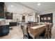 Spacious kitchen with dark cabinetry, stainless steel appliances, and an island seamlessly connected to the dining area at 9768 Fox Estate St, Las Vegas, NV 89141