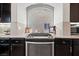 Kitchen features dark cabinets, a cooktop, mosaic backsplash, and granite countertops at 9768 Fox Estate St, Las Vegas, NV 89141