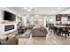 Inviting living area with a modern fireplace, neutral palette, comfortable sectional, and abundant natural light at 9768 Fox Estate St, Las Vegas, NV 89141