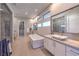 Bright bathroom featuring dual sinks, a soaking tub, walk-in shower, and dressing area at 10 Sugarberry Ln, Las Vegas, NV 89135