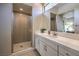 Modern bathroom features white quartz counters, white cabinets, and frameless glass shower with eye-catching geometric tile at 10 Sugarberry Ln, Las Vegas, NV 89135