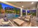 Stylish outdoor living space with a covered patio, comfortable seating, and views of the lush backyard landscaping at 10 Sugarberry Ln, Las Vegas, NV 89135