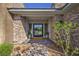 Inviting entryway with stone accents, a covered porch, and a modern glass front door with sidelights at 10 Sugarberry Ln, Las Vegas, NV 89135