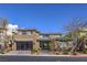Contemporary two-story home featuring a stone facade, a glass garage door, and professional landscaping at 10 Sugarberry Ln, Las Vegas, NV 89135