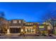 Contemporary two-story home with a stone and stucco facade and a glass-paneled garage door at twilight at 10 Sugarberry Ln, Las Vegas, NV 89135