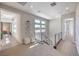 Sunlit upstairs hallway with modern railings, neutral carpet, and views to the exterior at 10 Sugarberry Ln, Las Vegas, NV 89135