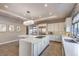 Well-lit kitchen with white cabinets, large island, stainless appliances and tiled backsplash at 10 Sugarberry Ln, Las Vegas, NV 89135