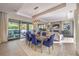 Open-concept living room showcases dining table, access to outdoor pool and lush landscaping, and stone fireplace at 10 Sugarberry Ln, Las Vegas, NV 89135