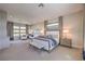 Spacious main bedroom featuring plush neutral carpeting, seating area, and lots of natural light at 10 Sugarberry Ln, Las Vegas, NV 89135