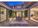 Charming outdoor patio with dining area, featuring a pergola, lush greenery, and elegant paving stones at 10 Sugarberry Ln, Las Vegas, NV 89135
