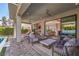 A covered patio with comfortable seating and a view of the pool and living area through sliding glass doors at 10 Sugarberry Ln, Las Vegas, NV 89135