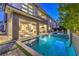 Outdoor living space featuring a modern pool, spa, covered patio, and lounge area, perfect for entertaining at 10 Sugarberry Ln, Las Vegas, NV 89135