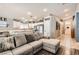 Open-concept living space featuring a large sectional sofa flowing into the bright, updated kitchen at 1010 Christopher View Ave, North Las Vegas, NV 89032