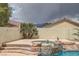 Rock waterfall spills into a hot tub in a backyard oasis surrounded by desert landscaping at 1010 Christopher View Ave, North Las Vegas, NV 89032